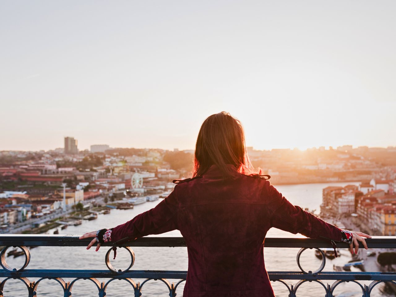 旅先の街を見渡す女性の後ろ姿