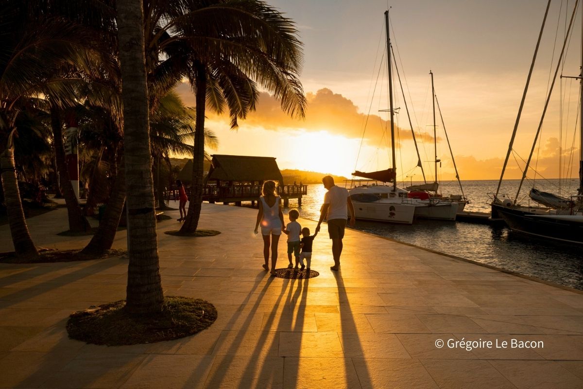 夕暮れのマリーナを家族で歩くタヒチでのバカンスのイメージ