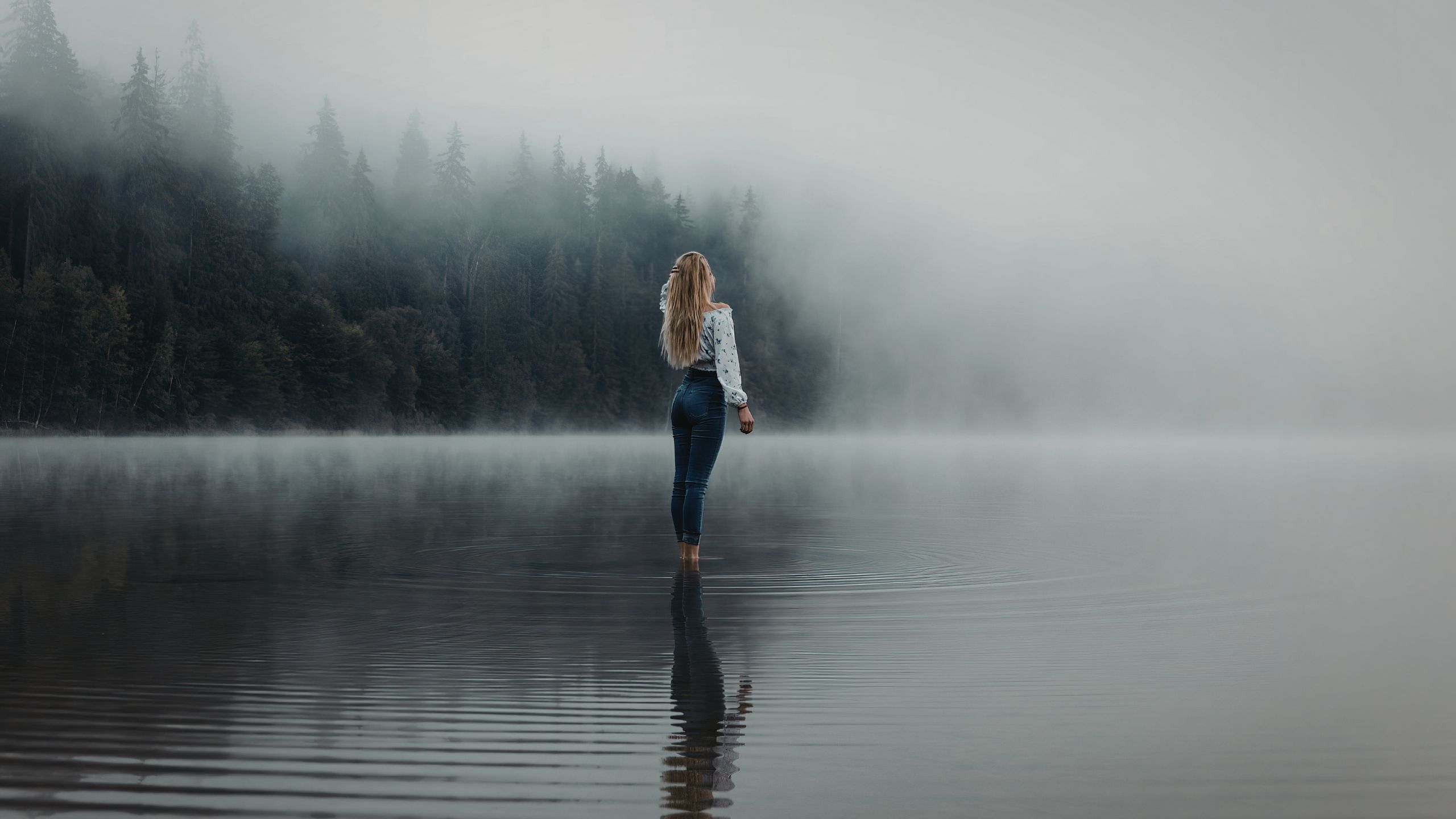 静かな水辺に立つ人物の風景